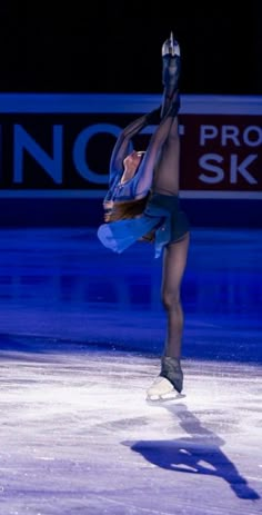 a man is skating on an ice rink with his arms in the air and one hand up