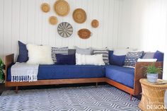 a living room with blue couches and wicker baskets on the wall above them