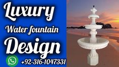 a white fountain sitting on top of a sandy beach next to the ocean at sunset