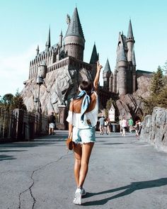 a woman walking in front of hogwarts castle