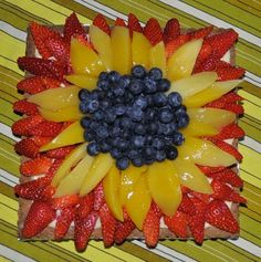 there is a piece of bread that has fruit on it and the shape of a sunflower