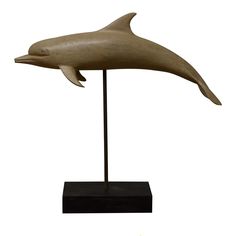 a bronze statue of a dolphin on a black stand