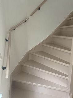 an empty room with white walls and stairs