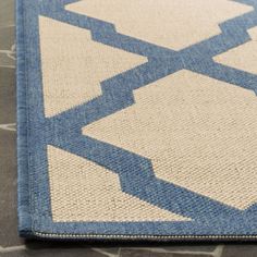 a blue and white rug on the floor with an interesting design in it's center