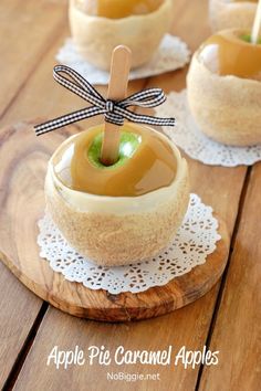 apple pie caramel apples are sitting in small bowls with sticks sticking out of them