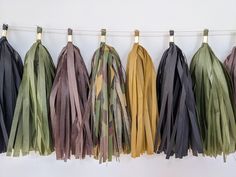 several different colors of tassels hanging on a line