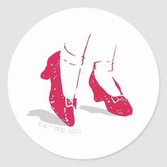 the feet of a person in red shoes on a white circle sticker with pink ink