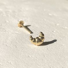 This Croissant stud piercing you are currently reviewing is entirely handmade, making each piece unique, even though they are produced to the same standards.  All components are crafted using 14-karat gold.     PRODUCT DETAILS:    Material: 14K Yellow Gold, 14K White Gold, 14K Rose Gold      Bar Thickness: 18 gauge / 1 mm  or 16 gauge/1.2 mm (please chose a variation) Bar Length Options: 5, 6, 7, or 8 mm (4 mm is too short for tragus and cartilage piercings. The thickness varies at each point of the ear. 6 mm is the most suitable length for cartilage and earlobe areas. If you have a smaller-than-average ear, please message for a 4 mm bar length.)    Closure: Internally Threaded Screw Flat Back / Screw Star Back (please choose a variation) Piercing Pin Dimensions: Lenght 7.5 mm/ Width 6 mm Back Piercings, Anti Tragus, Stud Piercing, Rose Gold Bar, Piercing Tragus, Cartilage Piercings, Piercing Cartilage, Helix Earring, Tragus Piercing