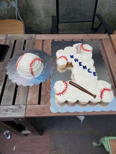 two cupcakes are sitting on a table with baseball themed frosting and icing