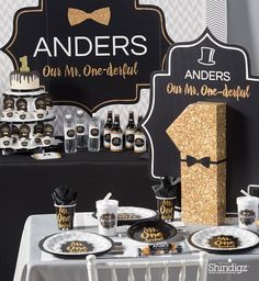 a black and gold themed birthday party with desserts, drinks and decorations on the table