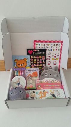 an open box filled with lots of toys and books on top of a white table