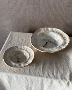 two white dishes sitting on top of a table