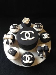 there is a chanel cake on the plate with cupcakes