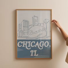 a woman standing in front of a chicago poster with her hand on the back of it