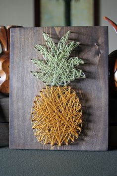 a pineapple is on a wooden board with some string attached to the top and bottom