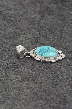 This Kingman turquoise and sterling silver pendant was made by Navajo silversmith Daniel Benally. The back is stamped RB and .925.Length: 1 3/4"Width: 3/4"Free shipping on all orders! We ship with USPS and always include tracking. All orders ship within a day of payment.Returns are accepted up to 30 days after you receive your order. Just send us a message. Our shop offers cash back or store credit. The item must be returned in new condition. Sterling Silver Turquoise Necklace With Concho, Sterling Silver Concho Pendant Jewelry, Silver Southwestern Turquoise Necklace With Round Pendant, Southwestern Sterling Silver Turquoise Concho Necklace, Southwestern Sterling Silver Round Pendant Jewelry, Nickel-free Silver Turquoise Necklace With Round Pendant, Instagram Jewelry, Spiritual Nickel-free Turquoise Pendant Necklace, Western-style Sterling Silver Turquoise Pendant Necklace