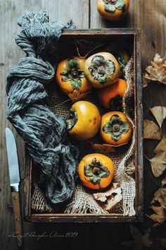 a box filled with lots of different types of fruit on top of a wooden table