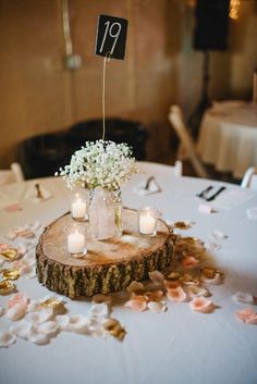 a centerpiece with flowers and candles on a table