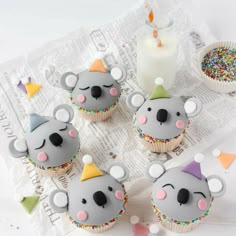 some cupcakes that have been decorated to look like koala bears with party hats on