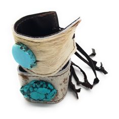 Show off your boho-chic style with this women's leather cuff bracelet! This piece of genuine leather cuff jewelry features a turquoise slab sewn to the center. This women’s cuff bracelet is handcrafted with genuine leather and hide, adding a southern touch to your boho-chic style. Adjusts with leather ties and a wood bead that can be moved to accommodate a variety of wrist sizes. The entire length of this women's cuff bracelet is 1.5" in width, and it adjusts with to the smallest size approximat Womens Cuff Bracelets, Leather Cuff Bracelet, Lace Cuffs, Cuff Jewelry, Turquoise Leather, Boho Accessories, Leather Cuffs Bracelet, Leather Cuffs, A Wood