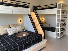 two bunk beds with stairs leading up to the top bed and below them is a table with pillows on it