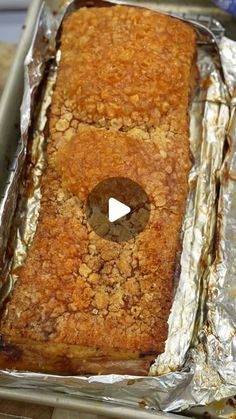 a loaf of bread sitting on top of tin foil in a pan with a hole cut into it