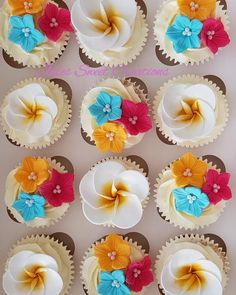 cupcakes decorated with colorful flowers on top of each other