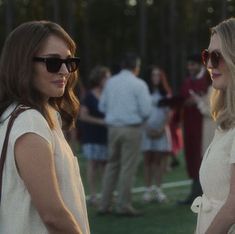 two women standing next to each other on a field