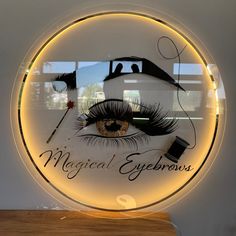 a lighted sign with an eye on it that says,'magical eyebrows '