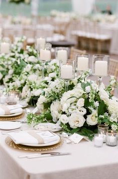 the table is set with white flowers and candles