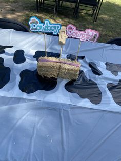 there is a cow print table cloth on top of the table with two straw baskets