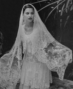 an old photo of a woman in a wedding dress with a veil on her head