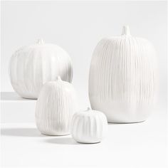 three white ceramic pumpkins sitting next to each other