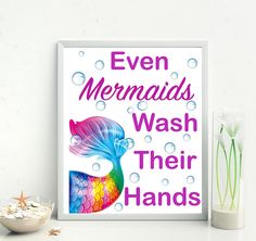 there is a sign that says even mermaids wash their hands on the wall next to some seashells