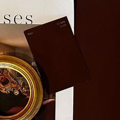 there is a book and a gold plate on the table next to it, with an image of a woman's face