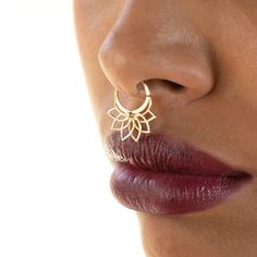 a close up view of a woman's nose wearing gold earring and red lipstick