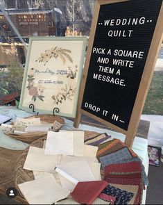 a table topped with lots of different types of cloths and fabric samples next to a sign that says wedding quilt