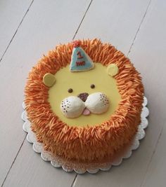 a birthday cake with orange icing and a lion face