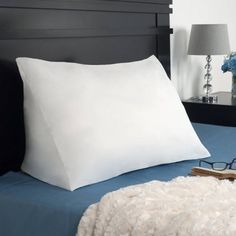 a pair of eyeglasses sit on top of a bed with white sheets and pillows