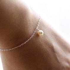 The most simple & delicate everyday bracelet. A dainty Swarovski crystal light cream pearl (6mm) floats from the most dainty & shimmering sterling silver chain. Bracelet is completed with a round spring clasp. ♥Also available in gold fill: https://www.etsy.com/listing/104812683/dainty-everyday-gold-pearl-bracelet★★Need help with your bracelet size? Please measure your wrist, and add 1/2 - 3/4 of an inch for a comfortable fit! ♥Your purchase will come thoughtfully packaged and ready for g Dainty Sterling Silver Pearl Bracelet, Dainty Hypoallergenic Charm Bracelet For Weddings, Classic Sterling Silver Charm Bracelet For Wedding, Delicate Adjustable Charm Bracelet, Sterling Silver Round Charm Bracelet For Wedding, Delicate Sterling Silver Chain Bracelet For Anniversary, Dainty Silver Charm Bracelet For Bridesmaid Gift, Elegant Adjustable Pearl Bracelet With Birthstone, Classic Bracelet Jewelry For Bridesmaid Gift