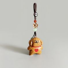 a small wooden dog with a heart on it's collar hanging from a string