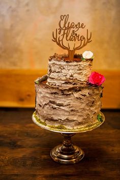 a close up of a cake on a table with a wooden sign in the middle