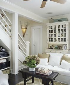 a living room filled with furniture and a ceiling fan in the middle of it's wall