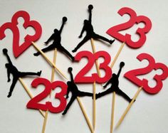 red and black cupcake toppers with the number 23 on them are made to look like basketball players