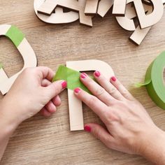 someone is cutting out the letters from construction paper and glues them into small pieces