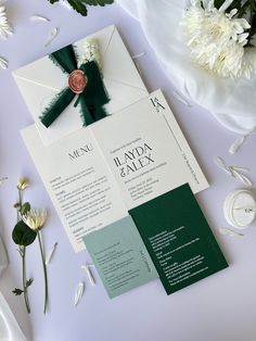 the wedding stationery is laid out next to flowers