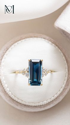 an engagement ring with a blue stone surrounded by diamonds