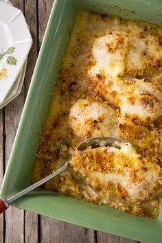 a green casserole dish filled with meat and cheese