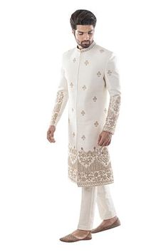 Ivory sherwani with all-over floral motif bead and zardozi work. Paired with plain straight pants.
Components: 2
Fabric: Raw silk, cotton
Neckline: Mandarin Collar
Sleeve Length: Full
Color: White
Embroidered

Closure: Sherwani: Concealed front placket - Aza Fashions Sherwani Pakistani, Ivory Sherwani, Dabka Work, Embroidered Sherwani, Wedding Kurta For Men, Groom Dress Men, Wedding Outfits For Groom, Wedding Dresses Men Indian, Mens Sherwani