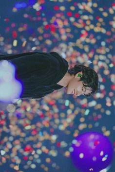 a woman looking up at the sky with confetti in the air behind her